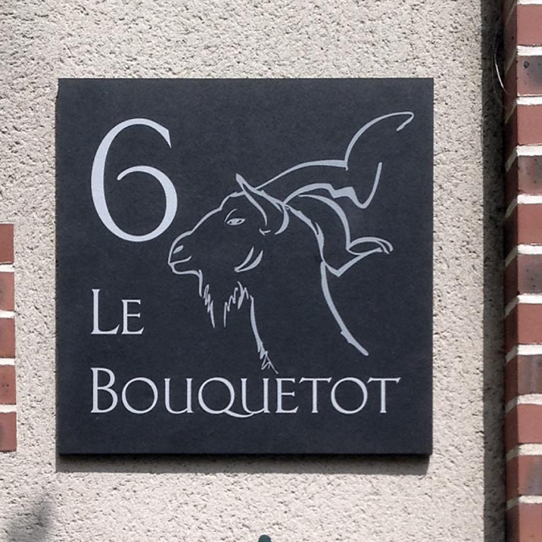 panneau décoratif avec le nom d'une maison et son numéro